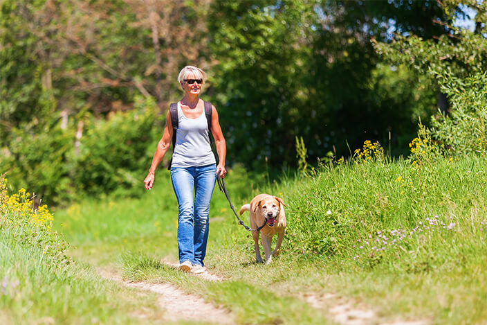 Woman Walking Dog in Park